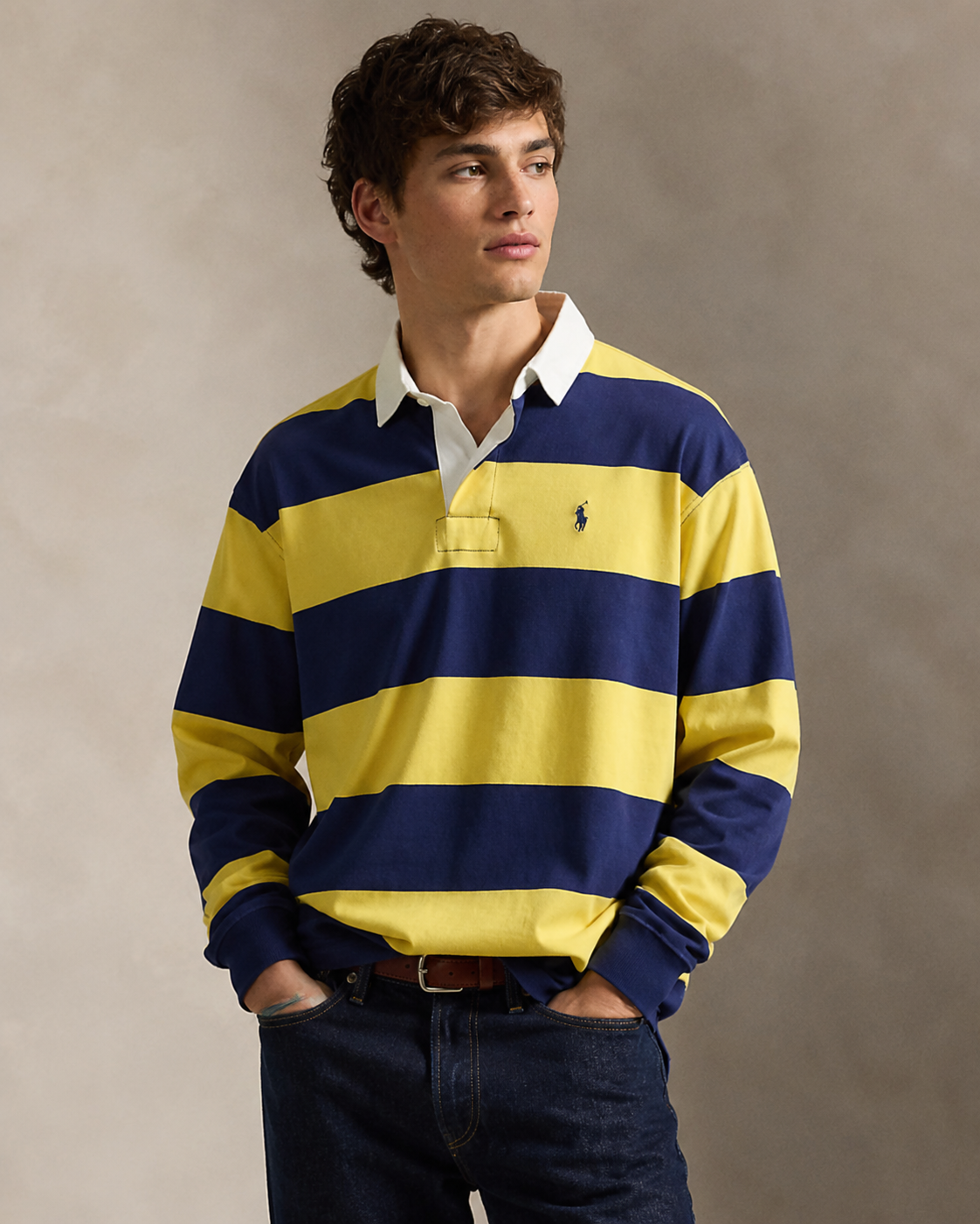 Model wearing a yellow and navy striped heritage rugby shirt with denim