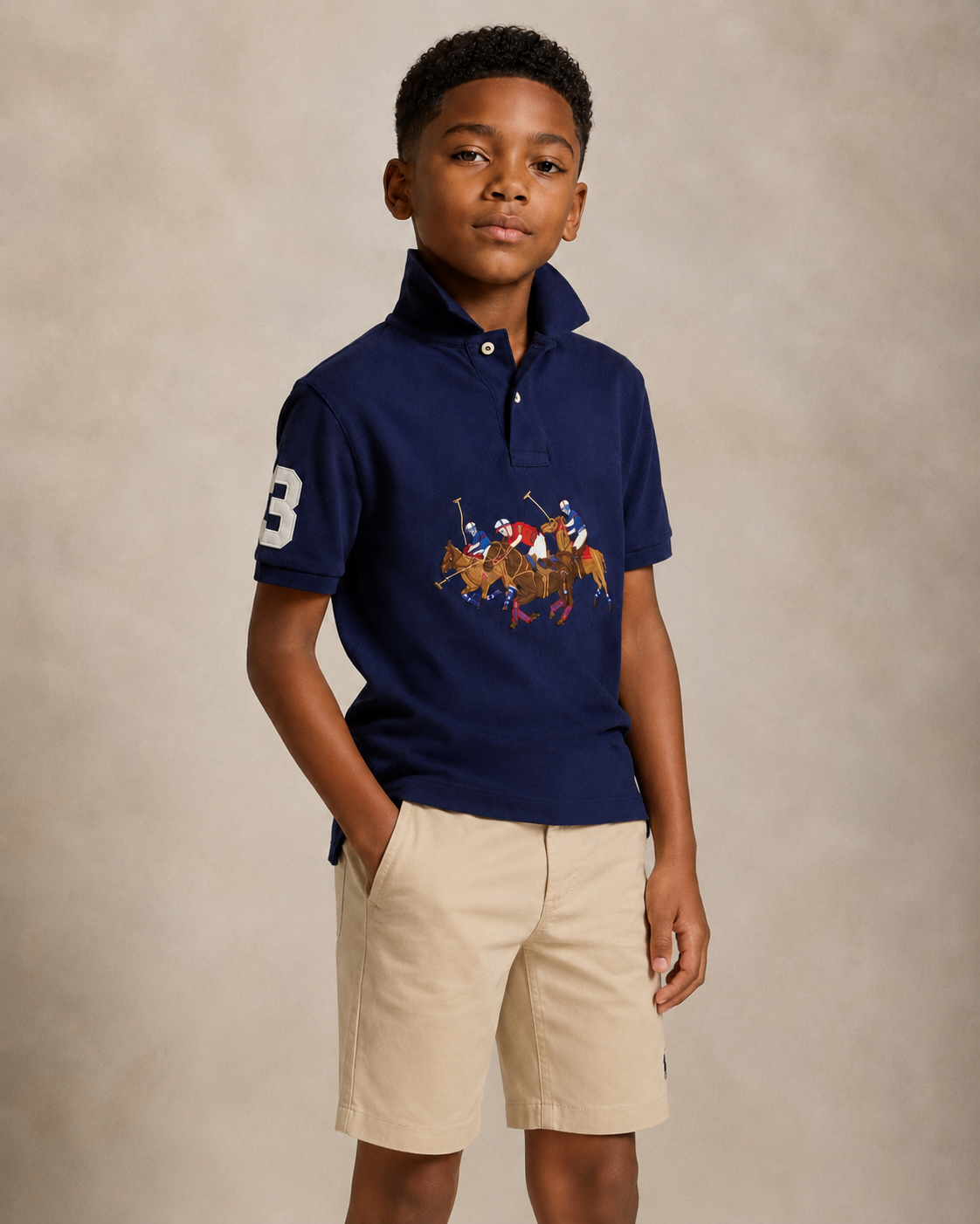 Child wearing a navy polo with cream shorts